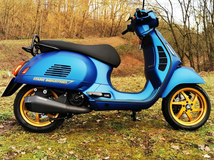 a blue scooter is parked in the grass