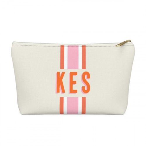 a white and pink cosmetic bag with the word kes printed on it's side