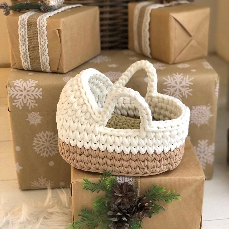 two wrapped presents sitting next to each other on top of brown boxes with white snowflakes