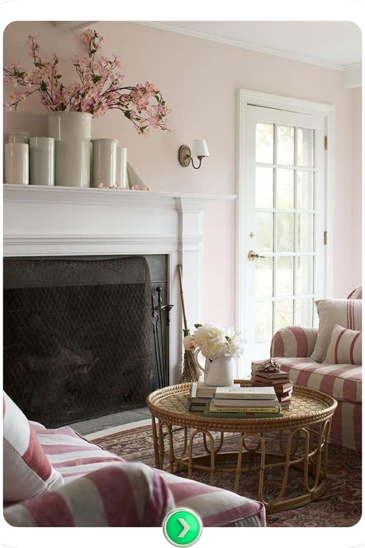 a living room filled with furniture and a fire place in front of a fireplace covered in pink flowers