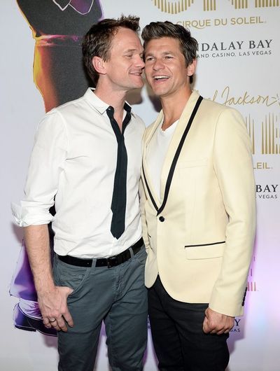 two men standing next to each other on a red carpet