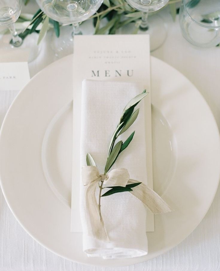 a place setting with white plates and napkins