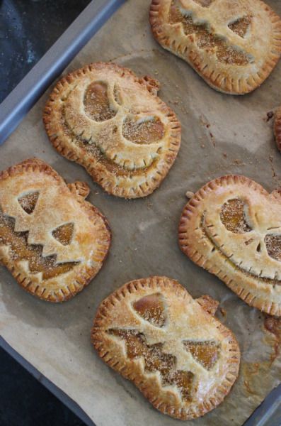 baked pastries with jack - o'- lantern faces on them