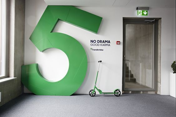 there is a large green number on the wall next to a small scooter