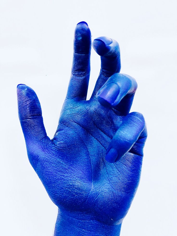 a person's hand with blue paint on it making the number one sign in front of them