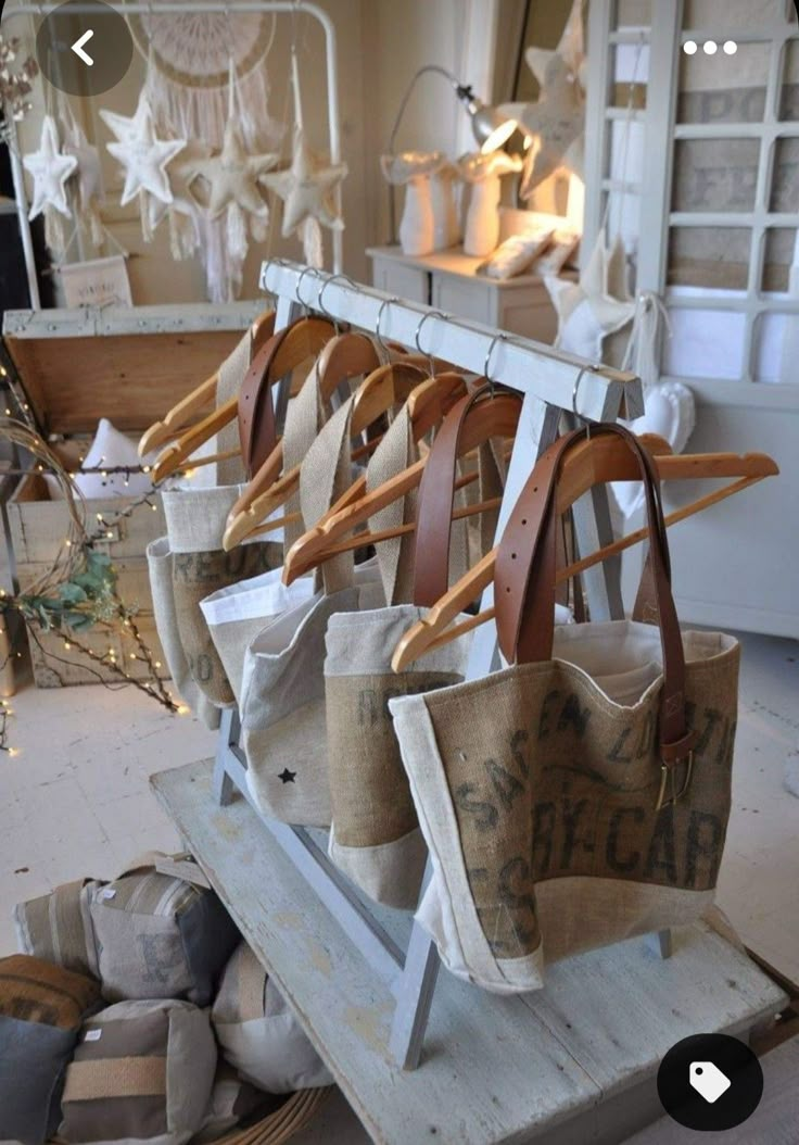 several bags hanging on clothes racks in a room