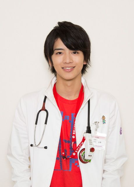 a young man with a stethoscope standing in front of a white wall