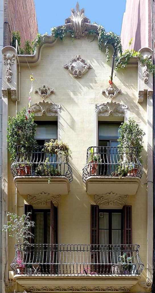 two balconies on the side of a building with plants growing out of them