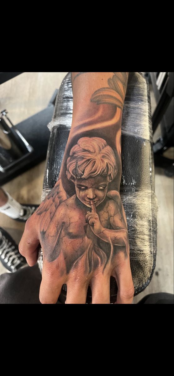 a man's hand with a tattoo on it that has an image of a woman holding