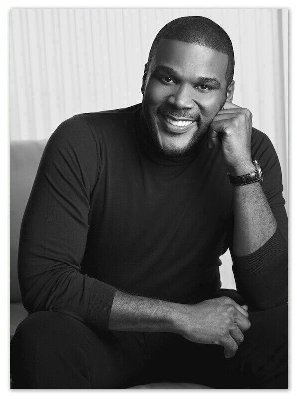 a smiling man sitting on top of a couch