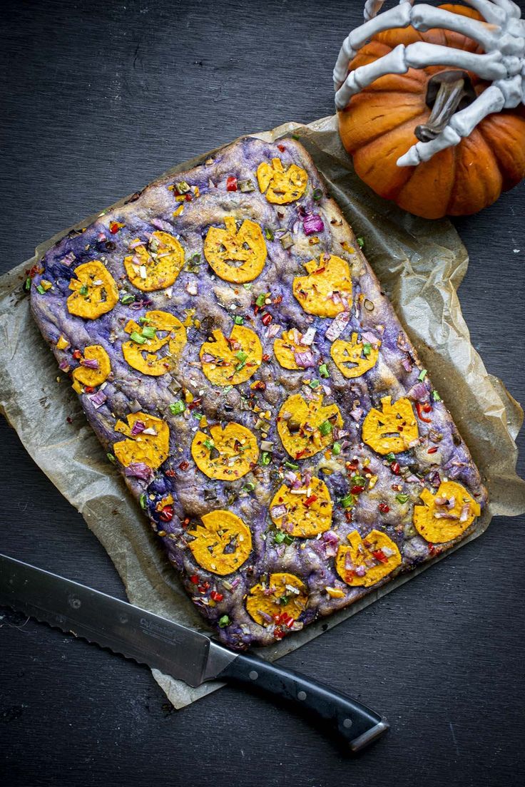 a knife and some food sitting on top of a piece of paper next to a pumpkin