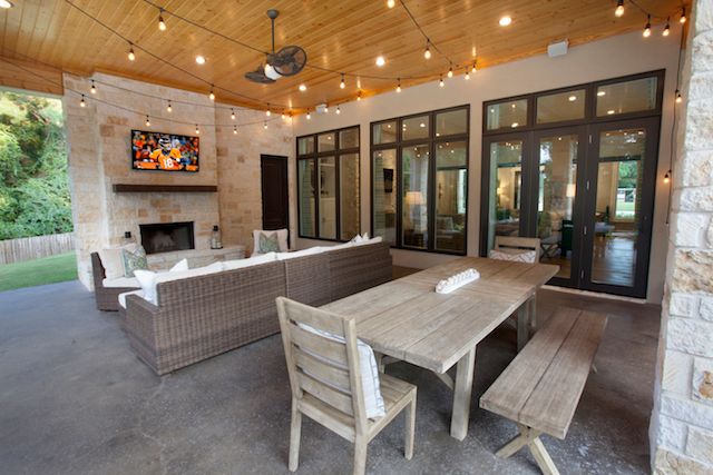 an outdoor living area with patio furniture and string lights