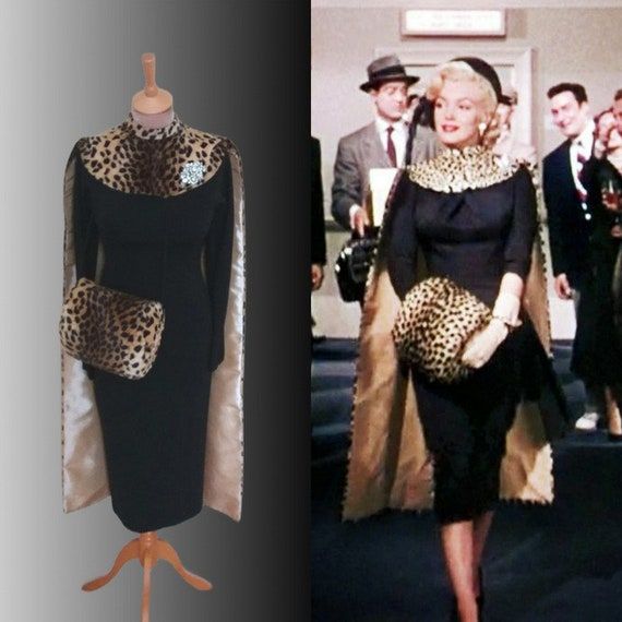 a woman in a black dress with leopard print on the collar and sleeves is next to a mannequin