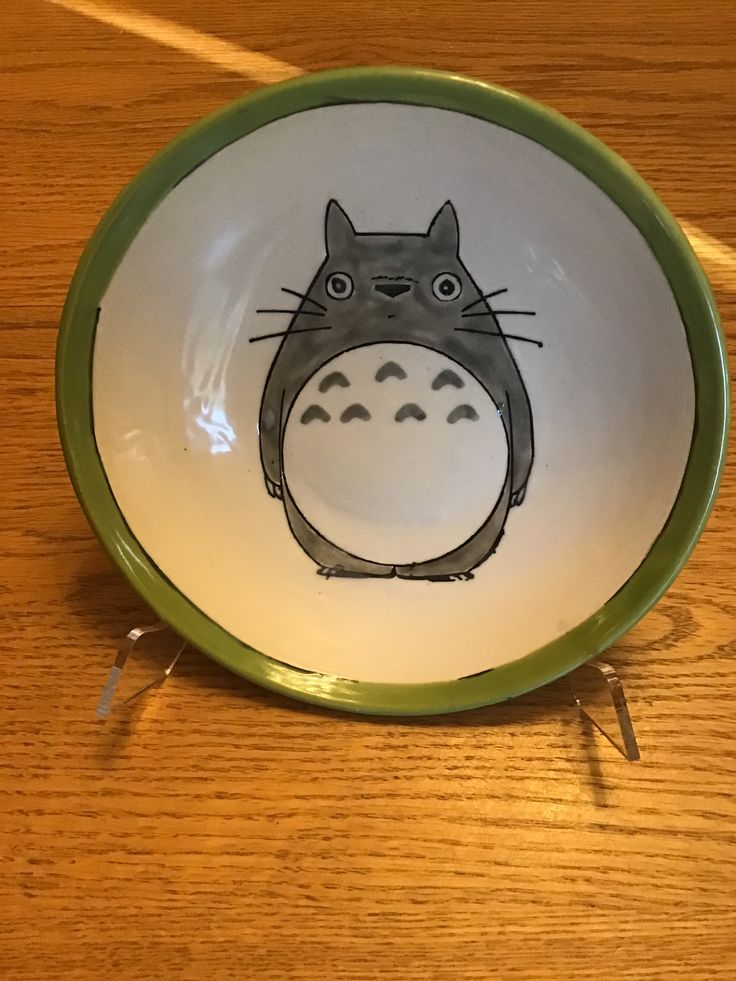 a bowl with a totoro drawn on the front in black, white and green