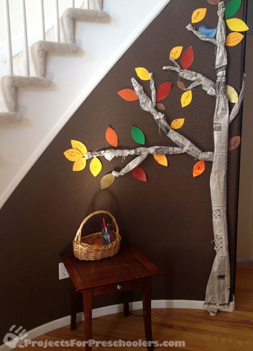 an image of a tree with leaves painted on it's wall in front of stairs