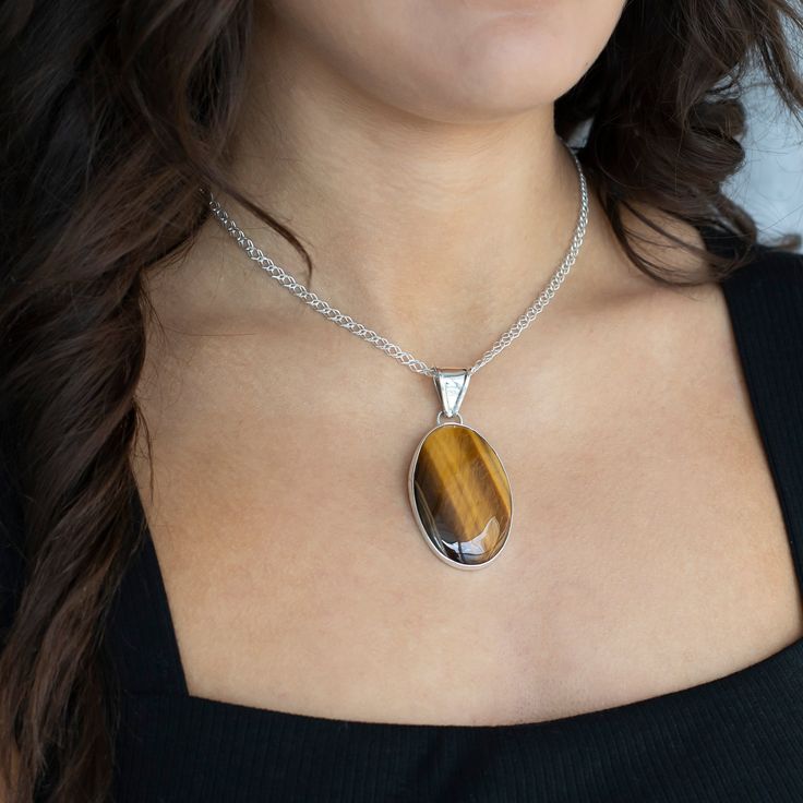 Looking for a little earthy flair? This Tiger’s Eye necklace has you covered. With its golden-brown shimmer and natural vibe, this stone brings all the warmth and glow you need to elevate any outfit. Set in sleek sterling silver, the necklace strikes that perfect balance between laid-back and eye-catching. Pendant only, the chain is sold separately here. Gemstone - Genuine Tiger's Eye 950 Sterling Silver Handmade in Taxco, Mexico Brown Gemstone Round Pendant Jewelry, Large Stone Round Necklace, Round Necklaces With Large Stone, Amber Oval Pendant Necklace, Elegant Brown Jewelry With Large Stone, Spiritual Brown Oval Pendant Jewelry, Brown Sterling Silver Round Pendant Necklace, Sterling Silver Brown Round Pendant Necklace, Brown Oval Natural Stone Necklace