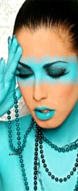 a woman with blue makeup is holding her hands to her face