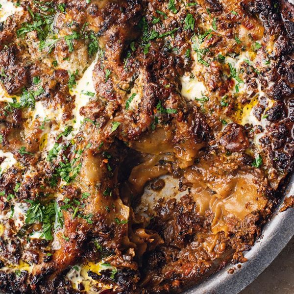 a close up of a pizza in a pan with cheese and meat toppings on it