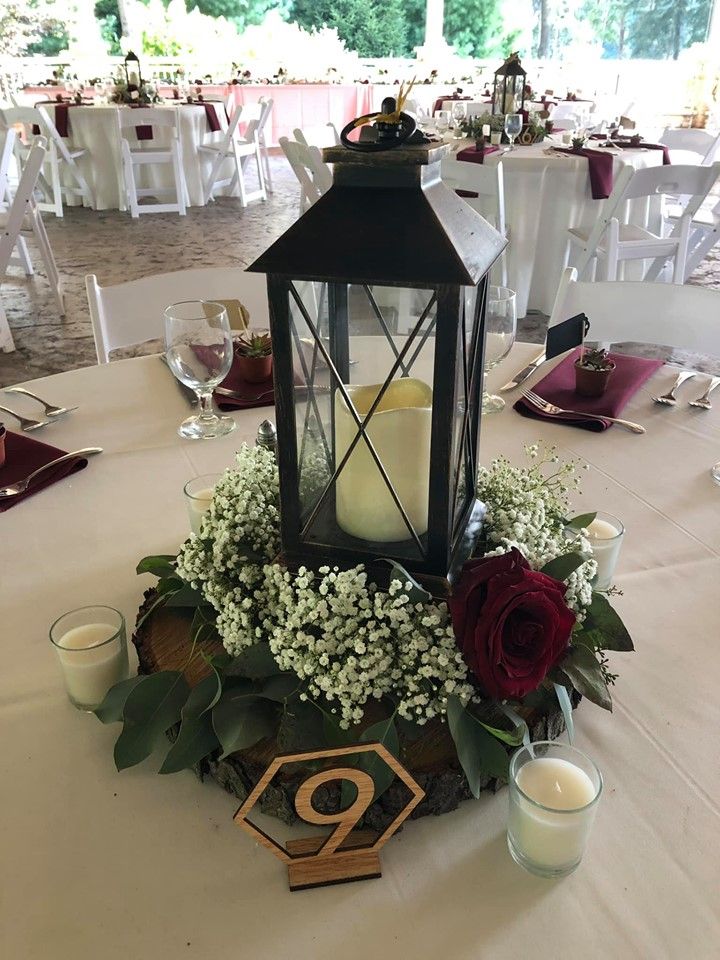 a lantern on top of a table with flowers and candles