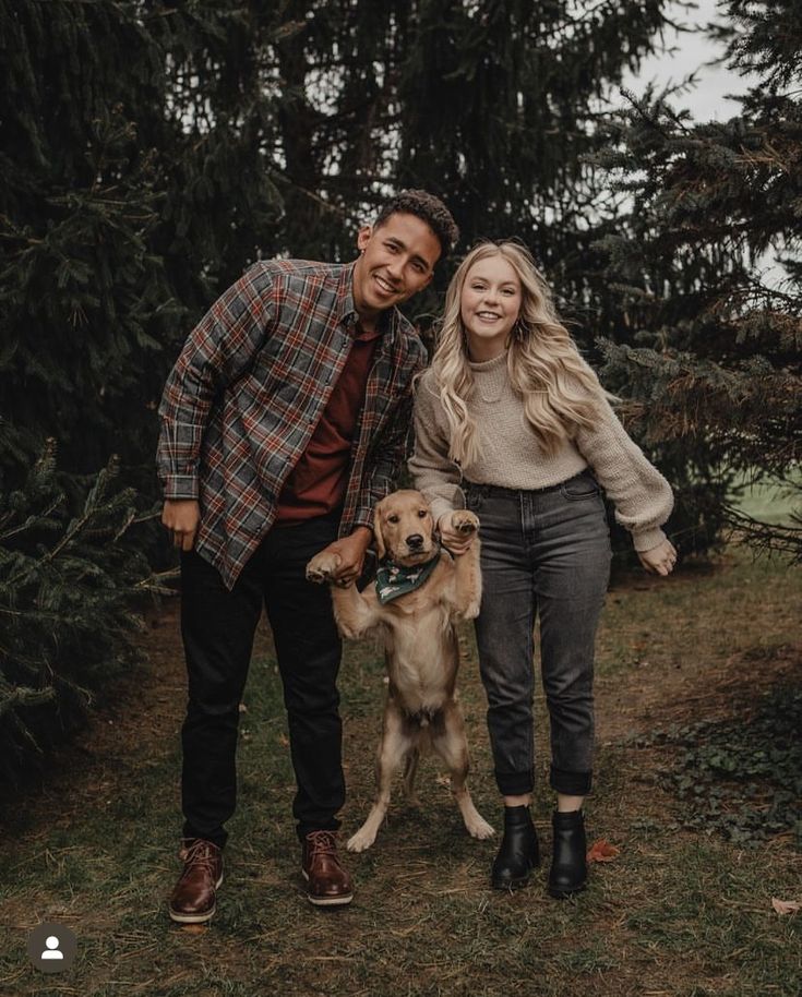 a man and woman standing next to a dog