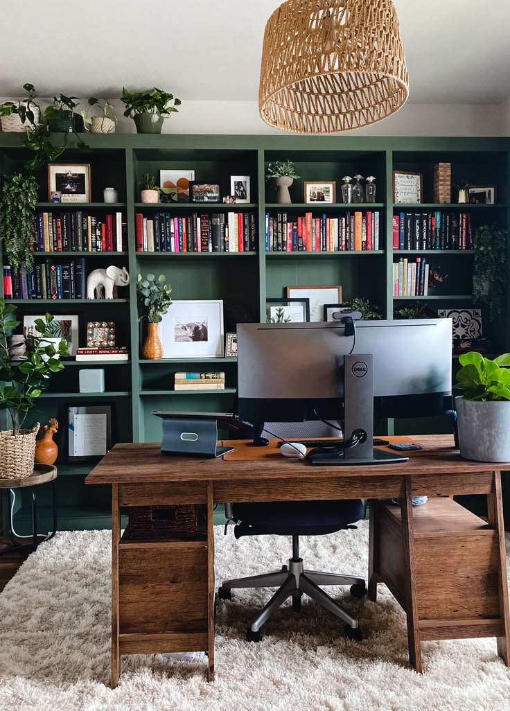 a home office with bookshelves, desk and computer on the far wall in front of it