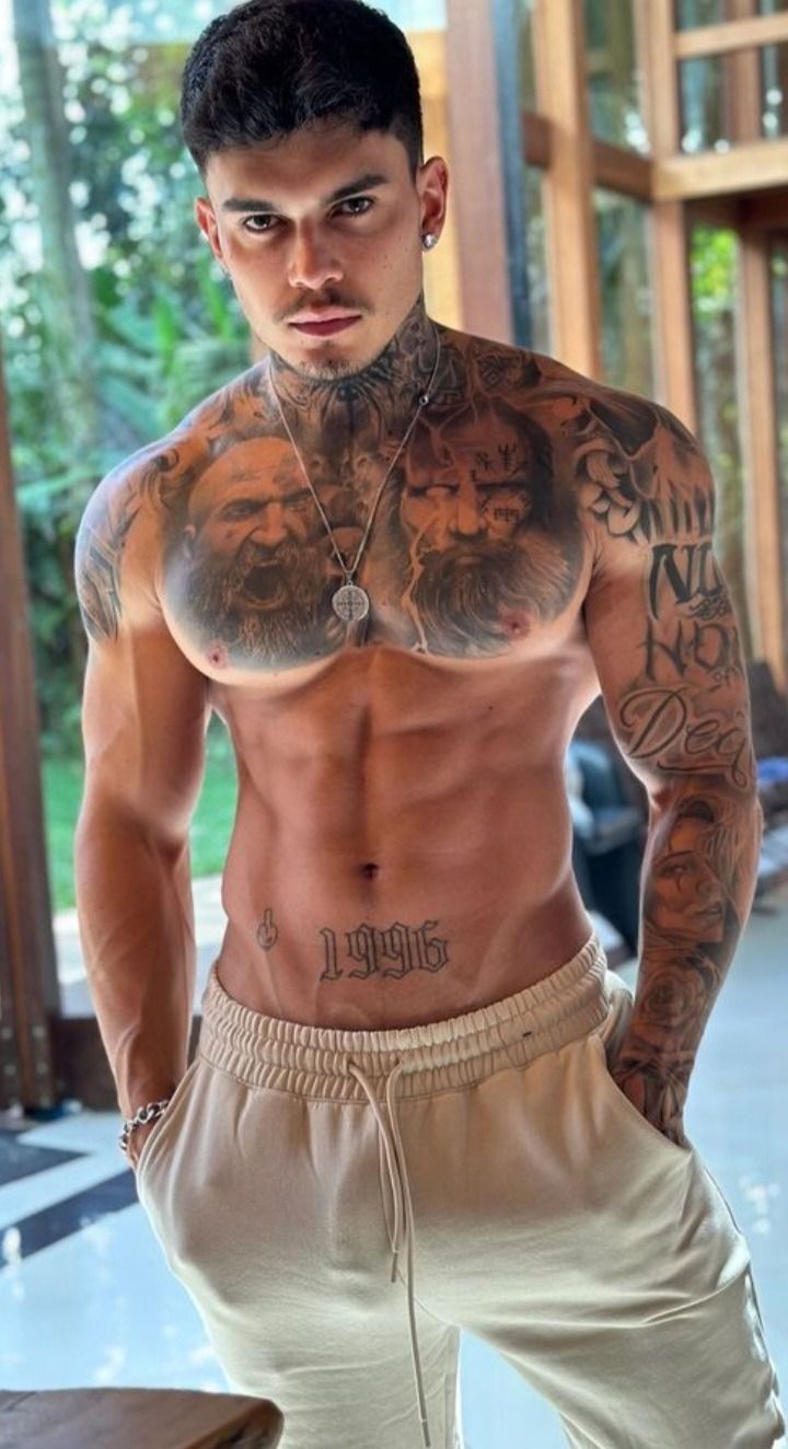 a shirtless man with tattoos on his chest