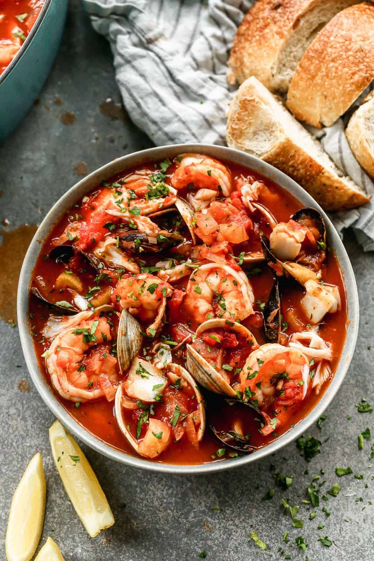 a bowl of seafood stew with bread on the side