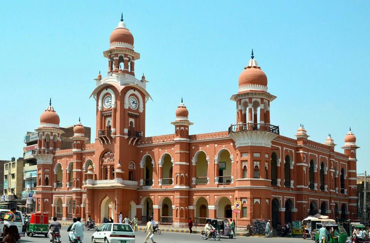 an old building with many cars parked in front of it