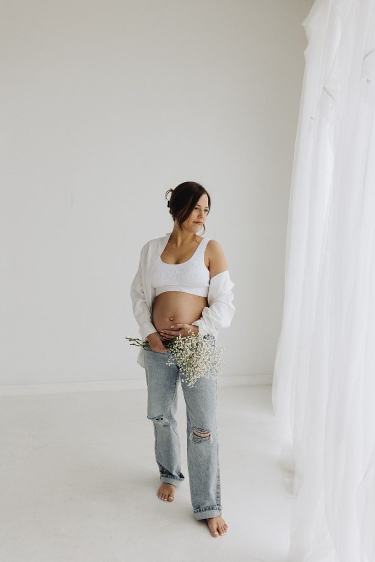 a pregnant woman holding flowers in her belly