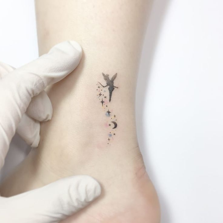 a person with a small tattoo on their foot is getting inked onto the ankle