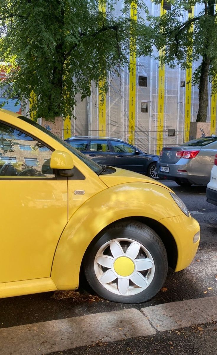 a yellow car is parked on the side of the street