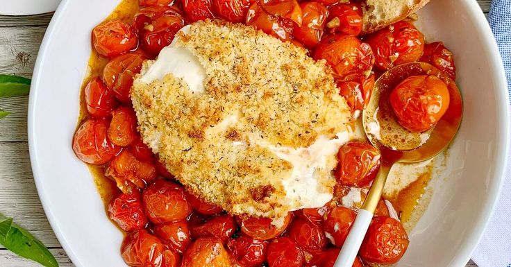 a white plate topped with tomatoes and bread