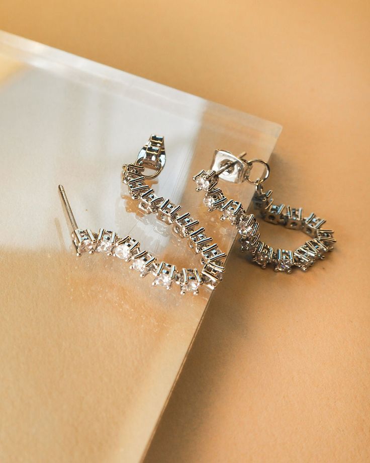 Pair of crystal-covered chain studs Sold as a pair for pierced ears Stud hangs down 0.95" (24mm) tall Set with 2mm round CZ stones Each earring weighs 1 gram Made from Brass with CZ Crystals Plated Silver Also available in Gold Posts are made from surgical steel so they are very hypo-allergenic for sensitive ears Earrings are 100% nickel-free and cadmium-free 1 year warranty Packaged in Luv Aj branded gift boxes Diamond Crystal Drop Earrings With Sparkling Stones, Diamond Drop Earrings With Sparkling Stones, Sparkling Diamond Dangle Crystal Earrings, Sparkling Crystal Dangle Diamond Earrings, Dangle Crystal Earrings With Bling For Anniversary, Diamond Drop Earrings With Rhinestones, Diamond White Bling Drop Earrings, Diamond Crystal Dangle Earrings For Pierced Ears, Diamond Dangle Crystal Earrings For Pierced Ears