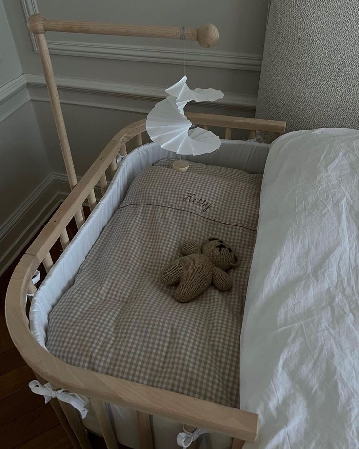 a teddy bear is laying in the crib