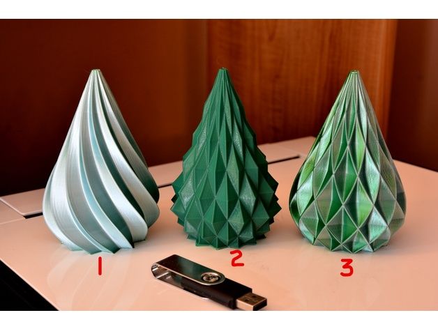 three paper christmas trees sitting on top of a table