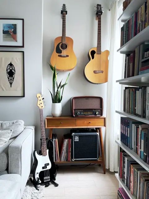 two guitars are hanging on the wall in this living room