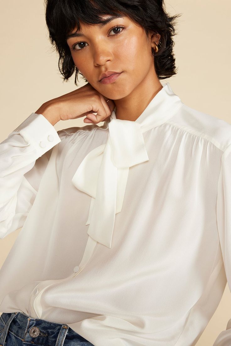 Make an impression with this washable silk bow blouse. The long ties at the neck and subtle puffed sleeves add an air of sophistication, yet it's easy care. DESIGN- Classic fit. Choose your usual size.- A button-front blouse with an elongated bow tie at the neck. Features short sleeves with a subtle puff. - Cuff detail with fabric covered buttons- Length: 25 1/2"FABRIC & CARE- 100% silk crepe de chine. Silk that is finely woven with subtle crepe texture so it reflects the light. Drapes beautiful Silk Blouse With Gathered Puff Sleeves, Chic Puff Sleeve Blouse With Bow, Express Bow-tie Blouse, Silk Button-up Blouse With Hidden Closure, Silk Ruffled V-neck Blouse, Cardigan Sweater Coat, Bow Blouse, Jumpsuit Skirt, Ethical Clothing