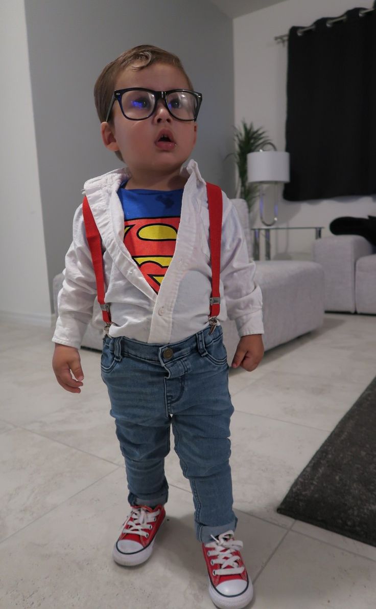 a little boy wearing glasses and a superman shirt