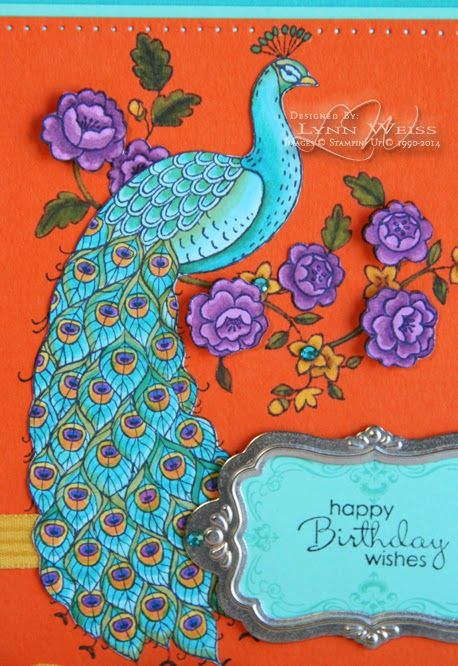 an orange birthday card with a blue peacock and purple flowers on the front, along with a happy birthday sign