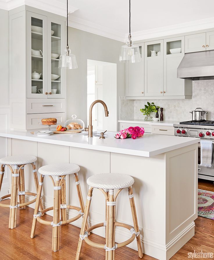 a kitchen with white cabinets and counter tops next to an island in the middle of the room