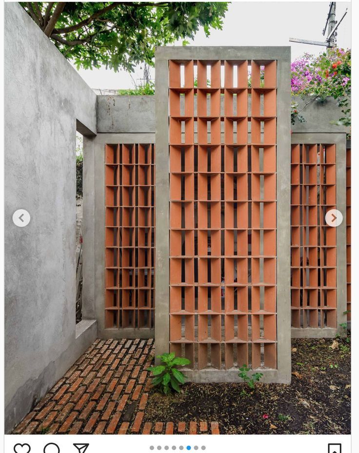 an image of a wooden fence made out of cinder blocks and bricks with flowers in the background