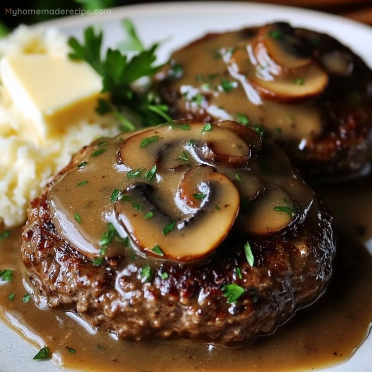 some meatloaf with mushrooms and gravy on top of mashed potatoes