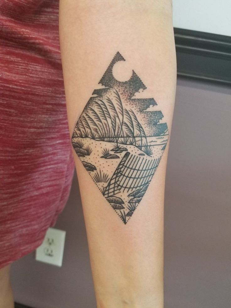 a person with a tattoo on their arm and the image of mountains is shown in black ink