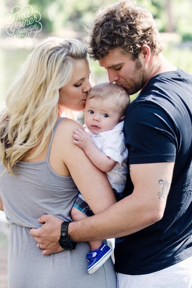 a man and woman holding a baby in their arms