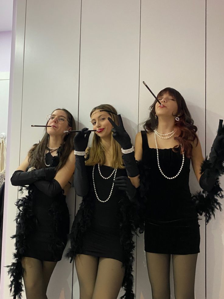 three women dressed in flappers and garters are standing next to each other