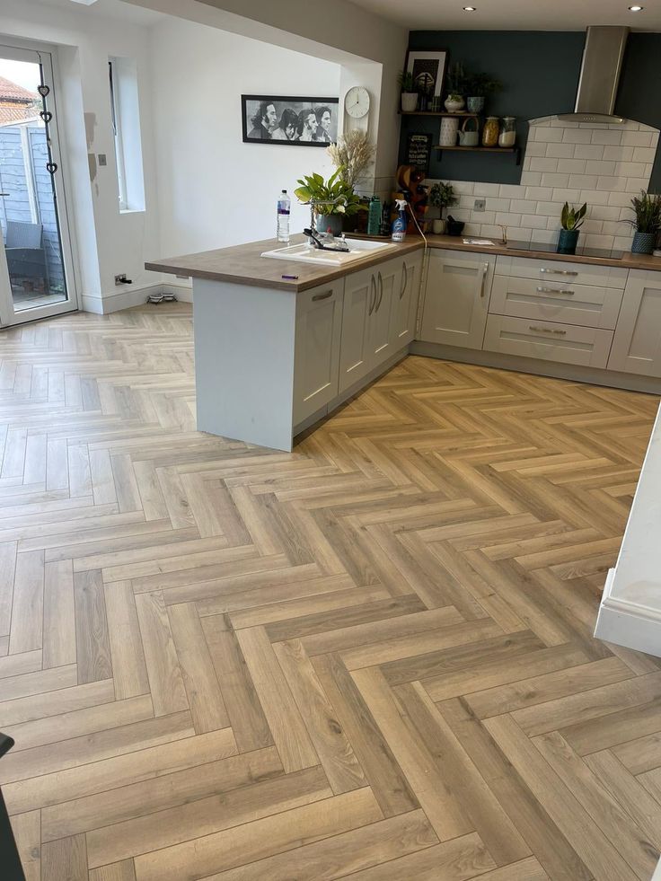 a kitchen with wood flooring and white cabinets