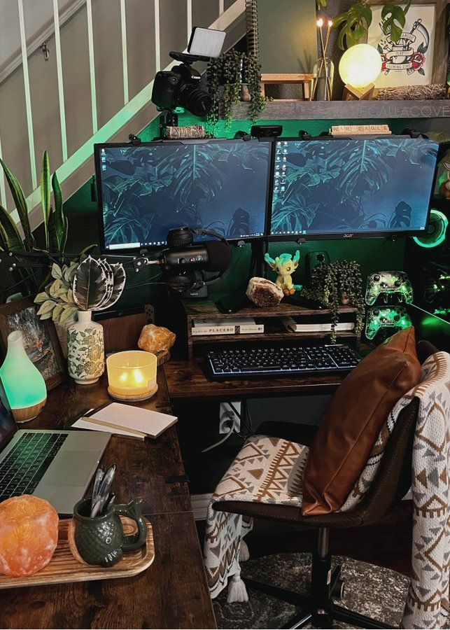 a desk with two computer monitors and a laptop on it, in front of a staircase