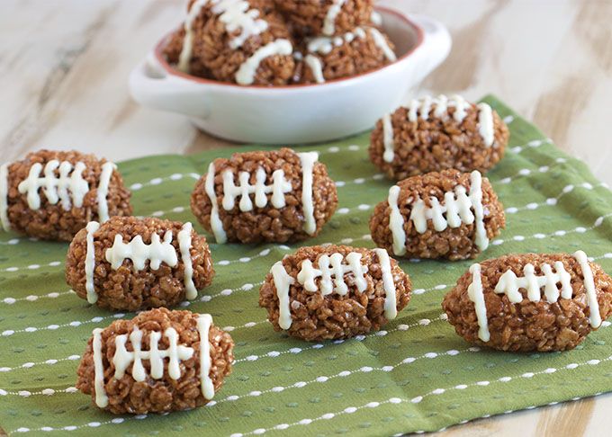 football cookies are arranged on a green cloth