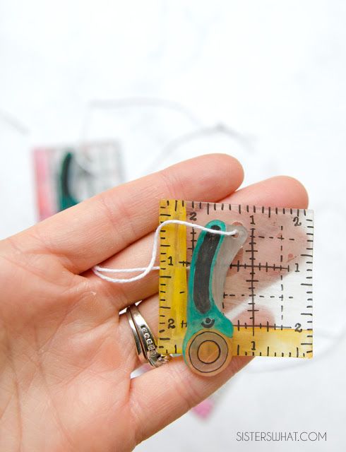 a person holding a pair of scissors in their left hand and measuring tape on the right