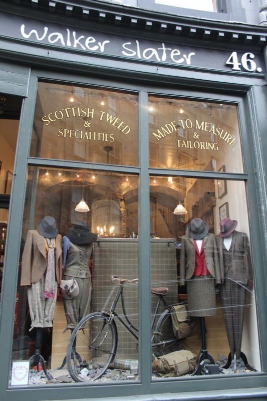 an old fashion store front with mannequins and suits in the window display